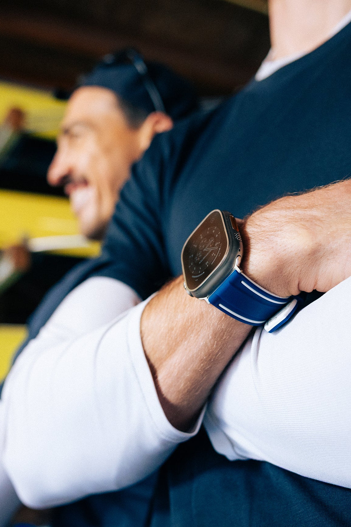 Rower with arms crossed wearing The Henley Apple Watch strap in blue