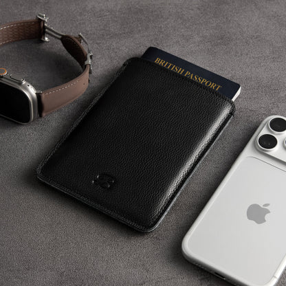 Black leather passport sleeve with Apple Watch and iPhone, angled close-up – The Bridge